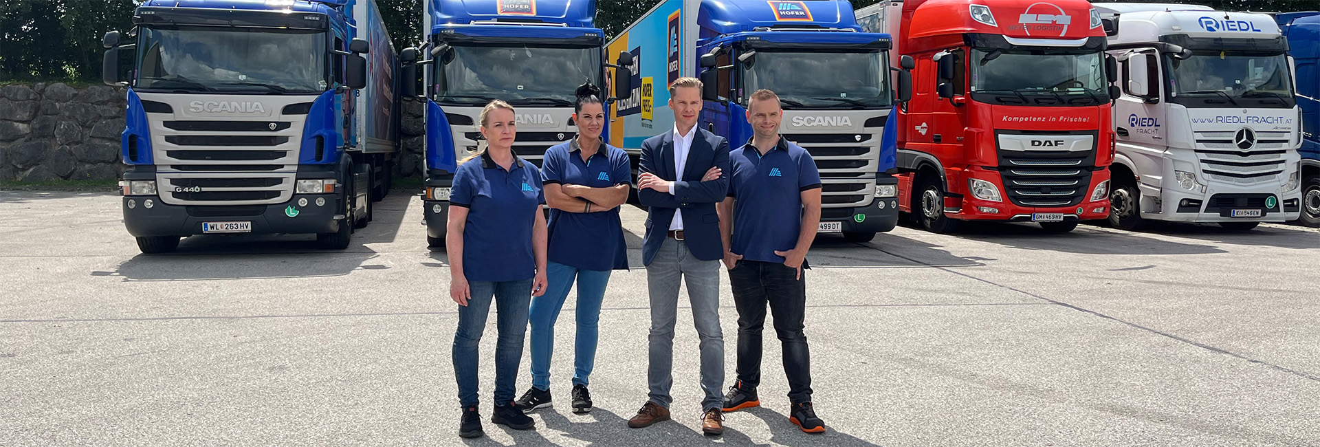 Mitarbeiter:innen vor LKW-Fuhrpark
