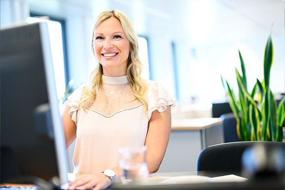 Arbeitsplatz einer Mitarbeiterin Mitarbeiterin arbeitet am PC